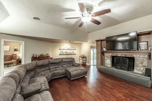 living room with ceiling fan, a fireplace, and dark hardwood / wood-style flooring