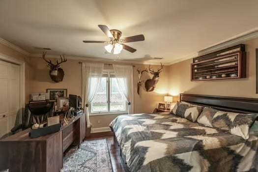 bedroom featuring dark wood-type flooring, ornamental molding, a closet, and ceiling fan