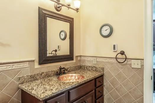 bathroom with vanity and tile walls