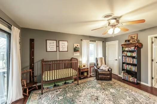 bedroom with multiple windows, hardwood / wood-style floors, and ceiling fan