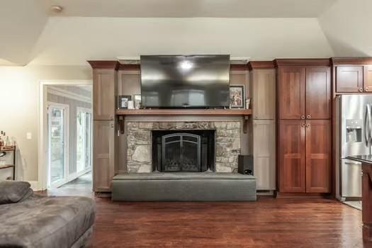 living room with a stone fireplace, lofted ceiling, and dark hardwood / wood-style flooring