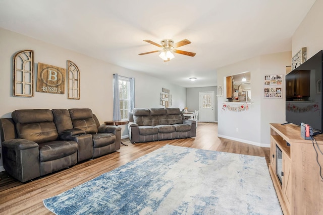 living room with ceiling fan and light hardwood / wood-style flooring