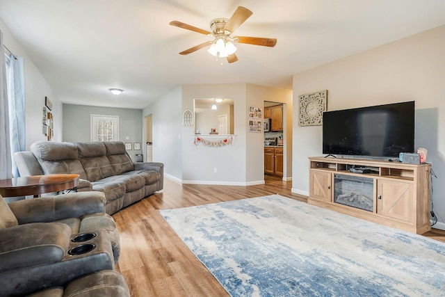 living room with ceiling fan and light hardwood / wood-style floors