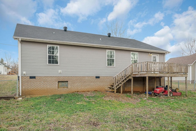 back of property featuring a wooden deck and a lawn