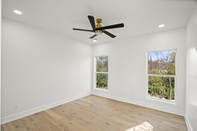 unfurnished room featuring ceiling fan, plenty of natural light, and light wood-type flooring