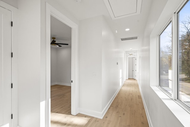 corridor with light hardwood / wood-style floors