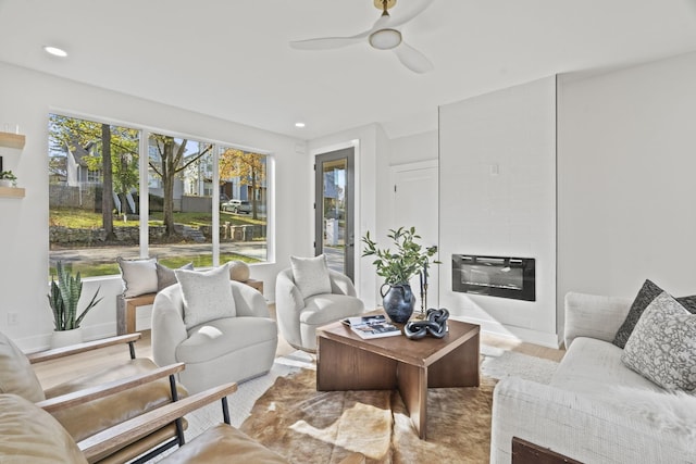 sunroom featuring ceiling fan, a fireplace, and heating unit