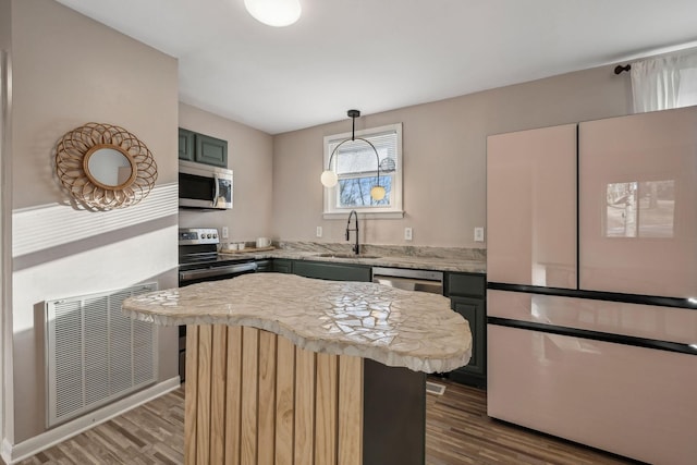 kitchen featuring sink, stainless steel appliances, green cabinetry, dark hardwood / wood-style flooring, and decorative light fixtures