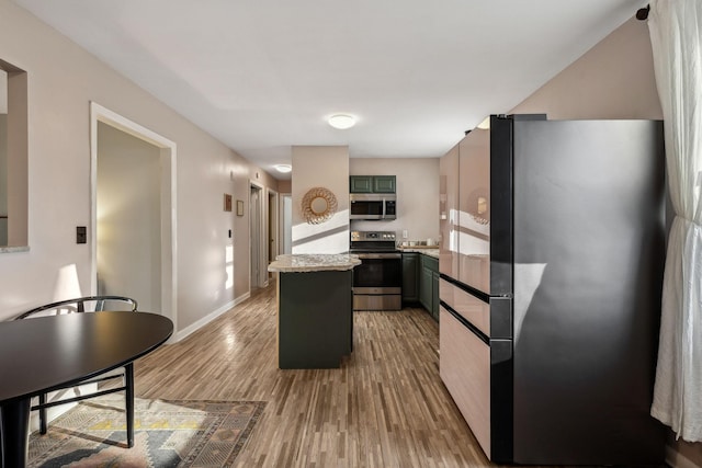 kitchen with hardwood / wood-style flooring, stainless steel appliances, a center island, and green cabinetry