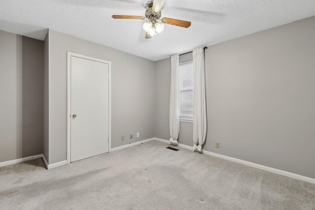 carpeted spare room with ceiling fan and a textured ceiling