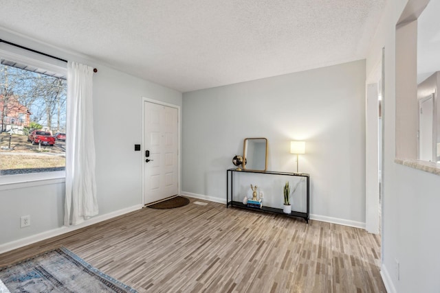 entryway with light hardwood / wood-style flooring and a textured ceiling