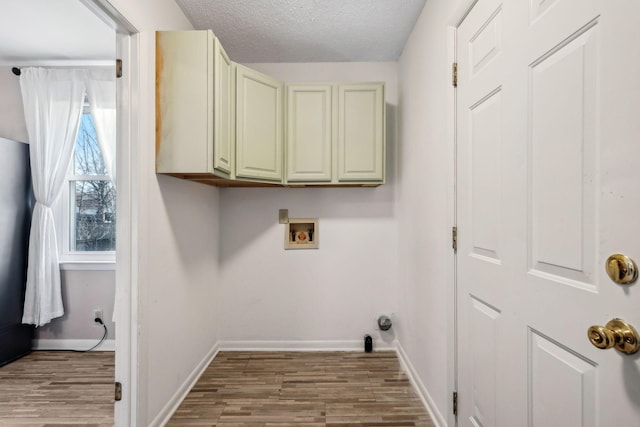 laundry area featuring cabinets, a healthy amount of sunlight, washer hookup, and a textured ceiling