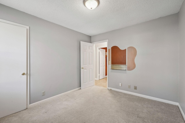 carpeted spare room with a textured ceiling