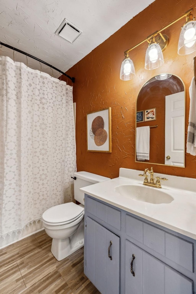 bathroom with vanity, a shower with shower curtain, and toilet