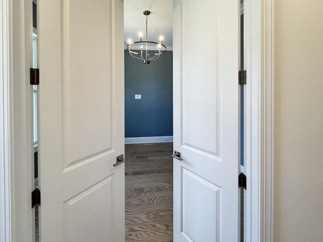 details with a notable chandelier and hardwood / wood-style flooring