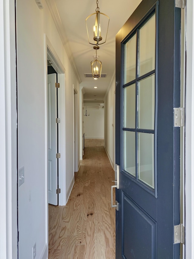 corridor featuring ornamental molding and light wood-type flooring