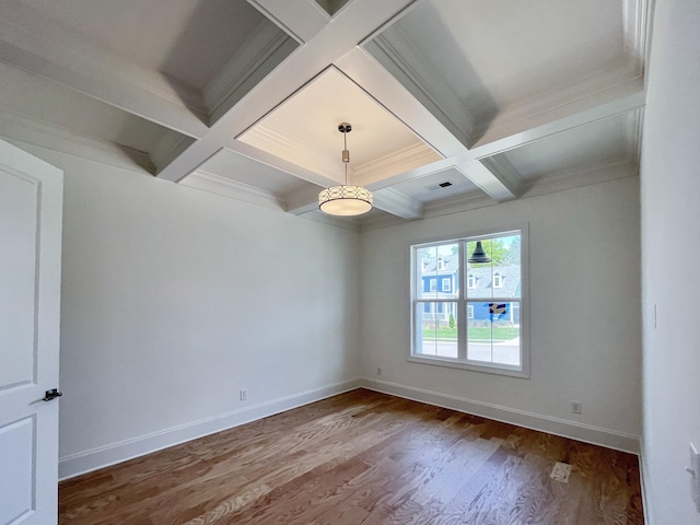 empty room with coffered ceiling, beam ceiling, wood-type flooring, and ornamental molding