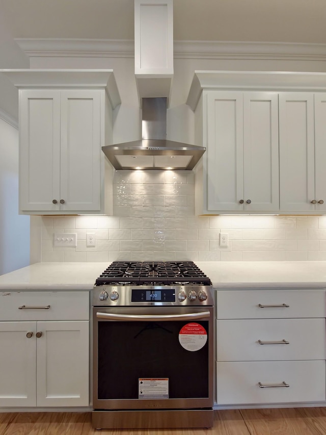 kitchen with backsplash, white cabinets, ventilation hood, and stainless steel gas stove