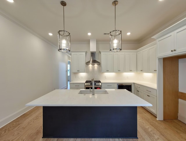 kitchen with white cabinetry, an island with sink, pendant lighting, and wine cooler