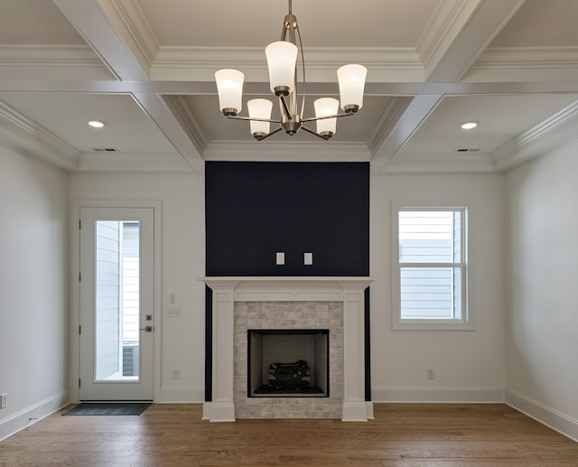 unfurnished living room featuring coffered ceiling, beam ceiling, a tile fireplace, and crown molding