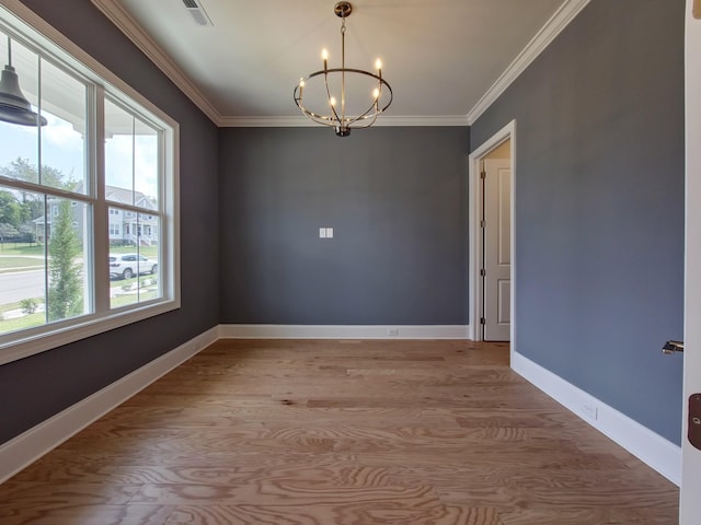 unfurnished room featuring ornamental molding, light hardwood / wood-style floors, and a notable chandelier