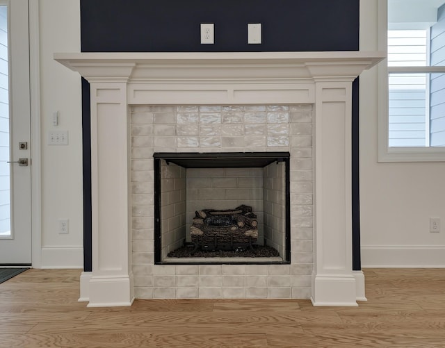 room details featuring wood-type flooring and a tile fireplace