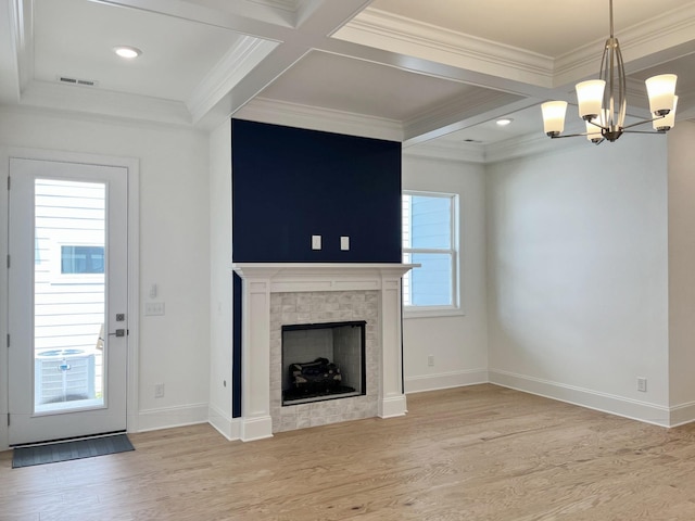 unfurnished living room with a tile fireplace, beam ceiling, coffered ceiling, ornamental molding, and light wood-type flooring