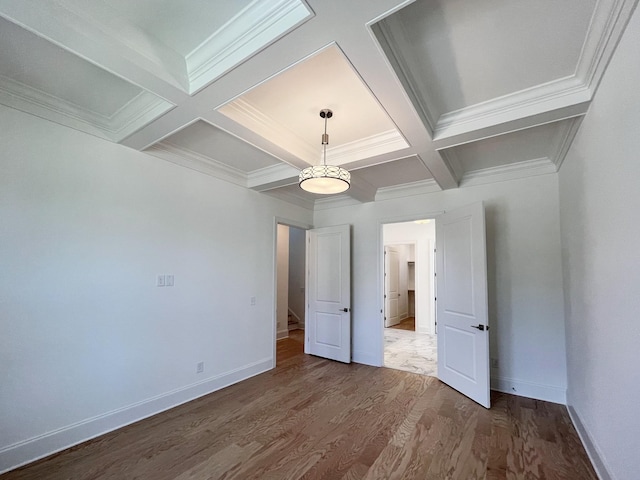 unfurnished bedroom featuring beamed ceiling, crown molding, coffered ceiling, and hardwood / wood-style floors