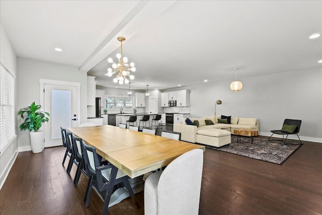 dining space featuring an inviting chandelier, sink, and dark hardwood / wood-style floors