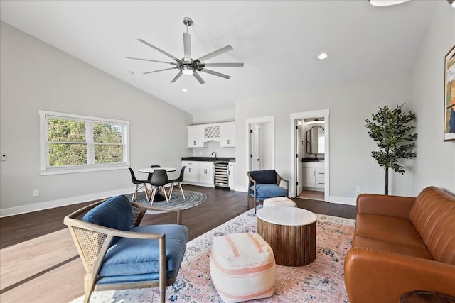 living room featuring sink, ceiling fan, dark hardwood / wood-style floors, vaulted ceiling, and beverage cooler