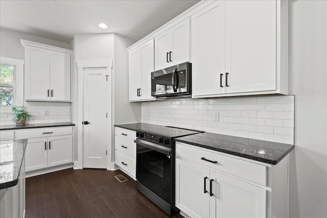 kitchen featuring white cabinetry, dark stone countertops, backsplash, and range with electric stovetop