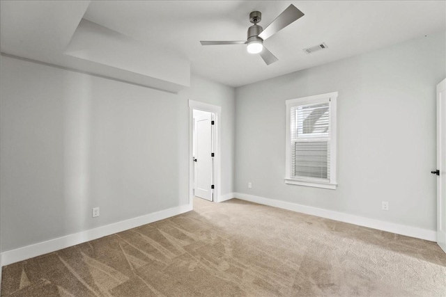 empty room with ceiling fan and light carpet