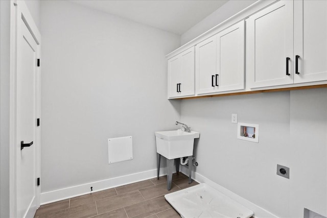 washroom featuring electric dryer hookup, washer hookup, and cabinets