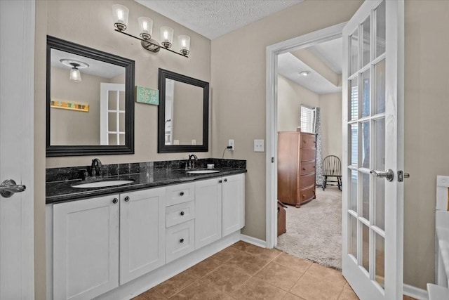 bathroom with vanity, tile patterned floors, a textured ceiling, and french doors