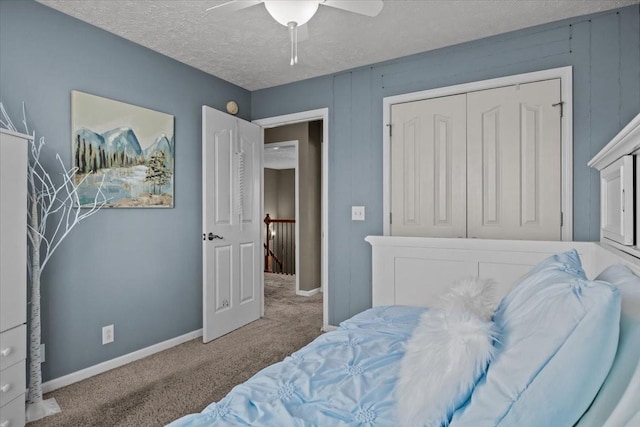 bedroom with a closet, ceiling fan, carpet, and a textured ceiling