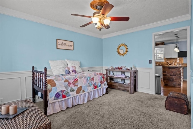 bedroom with crown molding, ceiling fan, light colored carpet, and a textured ceiling