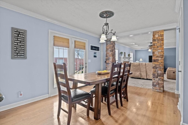 dining area with ornate columns, ceiling fan, light hardwood / wood-style floors, crown molding, and a textured ceiling