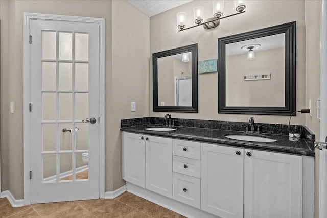 bathroom with vanity, tile patterned floors, and a textured ceiling