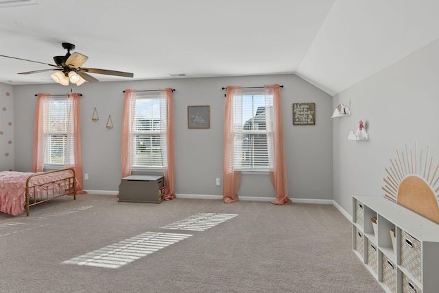 carpeted bedroom featuring ceiling fan, vaulted ceiling, and multiple windows