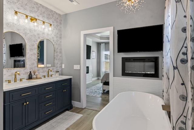 bathroom with vanity, a bath, and a notable chandelier