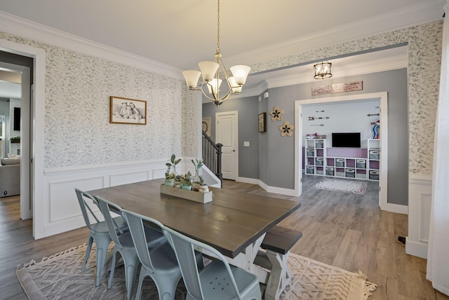 dining space with crown molding, a chandelier, and hardwood / wood-style floors