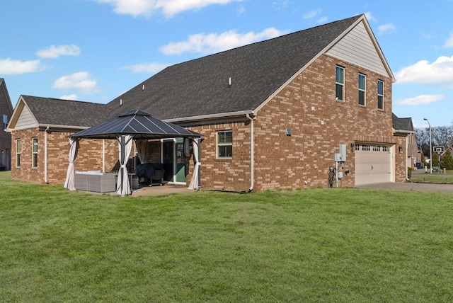 back of property with a gazebo, a garage, and a lawn