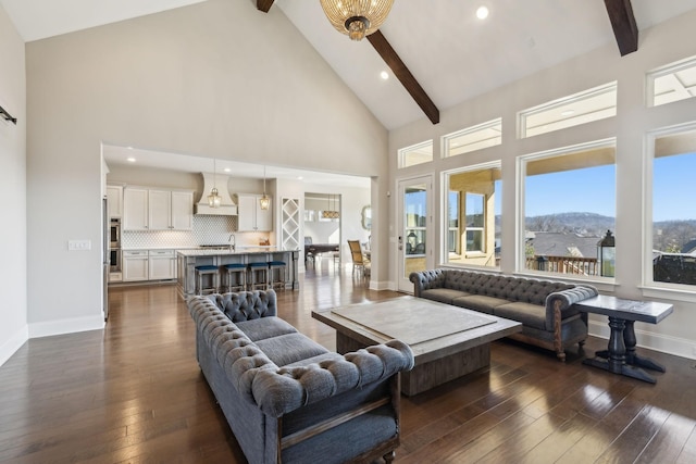 living room featuring dark hardwood / wood-style flooring, beam ceiling, a mountain view, and high vaulted ceiling