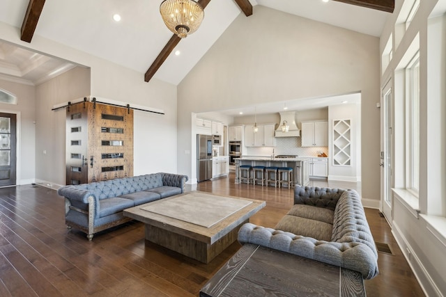 living room featuring dark hardwood / wood-style flooring, beam ceiling, high vaulted ceiling, and a barn door