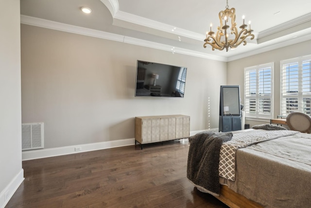 bedroom featuring ornamental molding, a chandelier, dark hardwood / wood-style flooring, and a tray ceiling