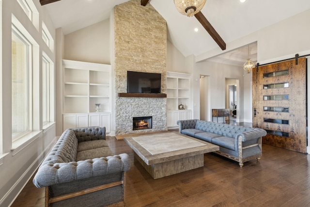 living room with dark wood-type flooring, a fireplace, a barn door, and beam ceiling