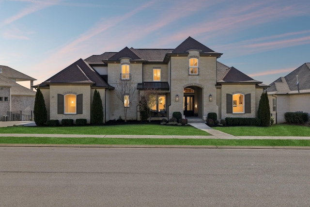 french provincial home featuring a lawn