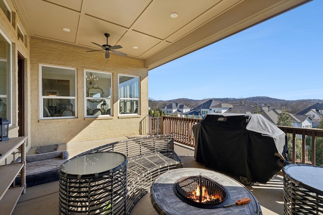 view of patio / terrace with area for grilling, a mountain view, ceiling fan, and an outdoor fire pit