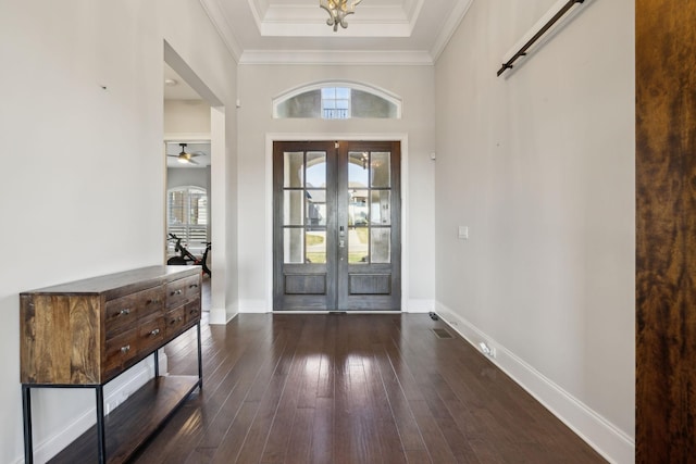 entrance foyer with french doors, crown molding, dark hardwood / wood-style flooring, a raised ceiling, and a barn door