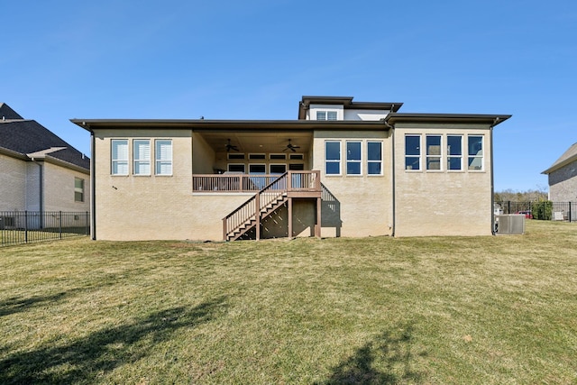 rear view of property with central AC, ceiling fan, and a yard